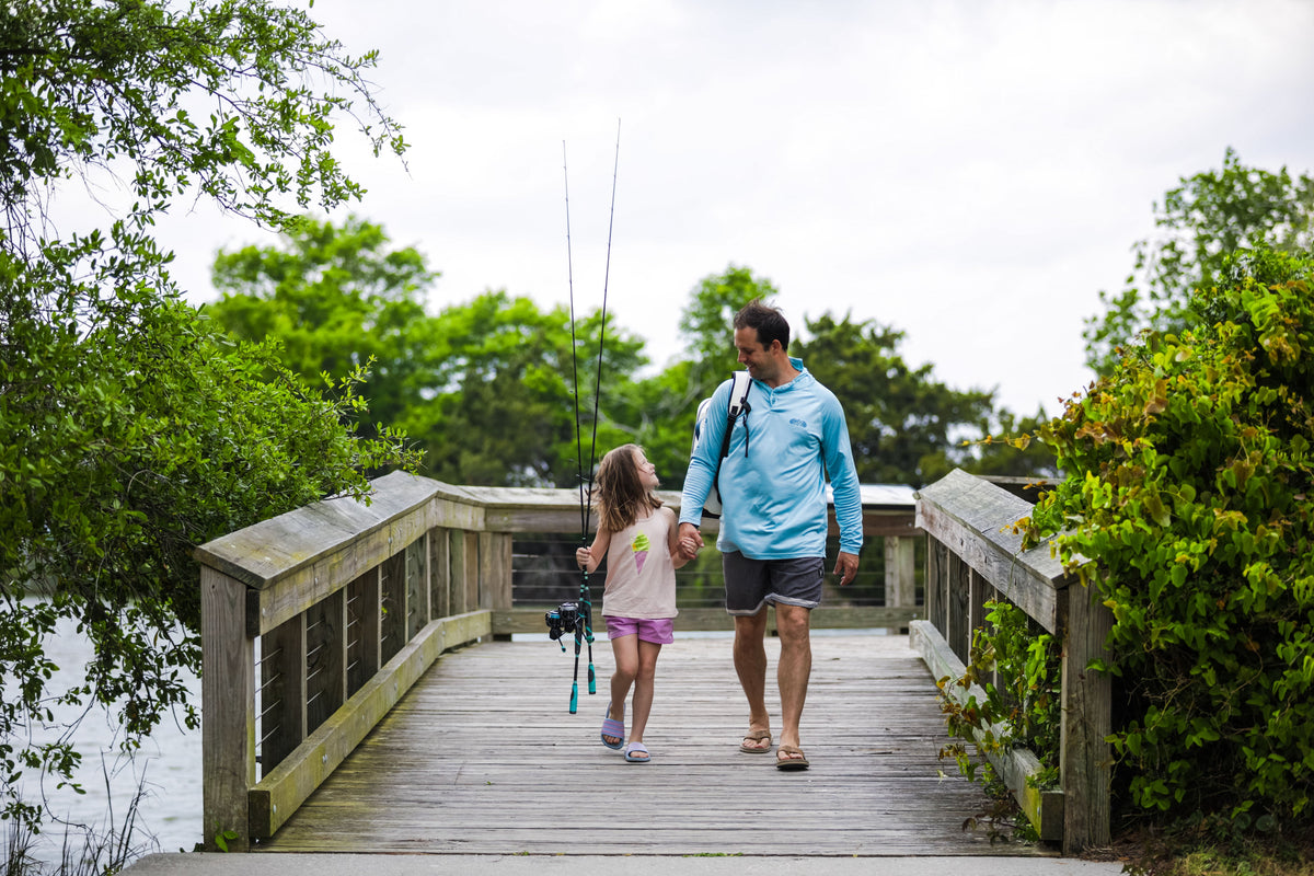a dad and daughter walk from fishing 